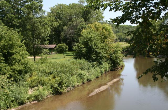 A river in the summer with a grassy area for recreational activities