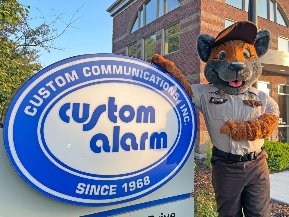Mascot Duke standing in front of Custom Alarm